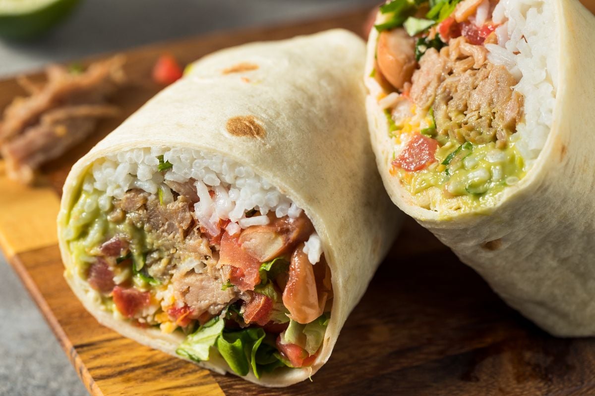 Carnitas pork burrito with rice cilantro and guacamole.