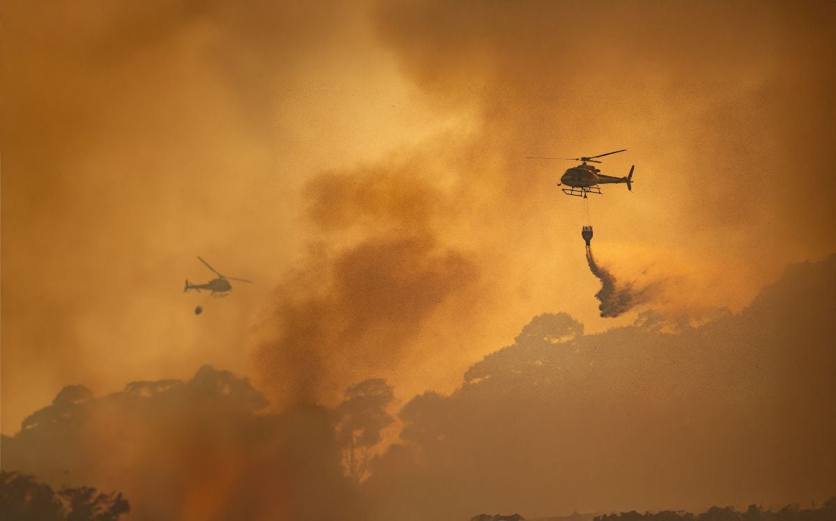 Fire fighting helicopter carry watethar bucket to extinguish the forest fire.