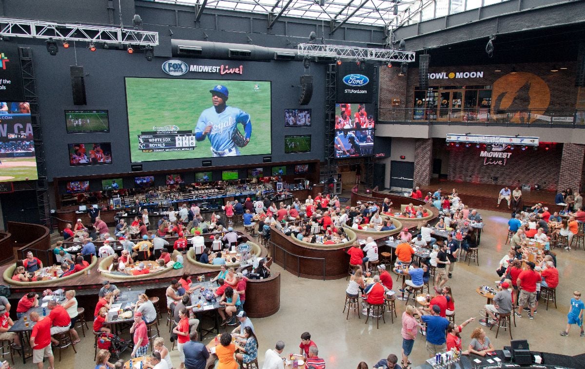 People eating and watching a baseball game at a restaurant in the Busch Stadium.