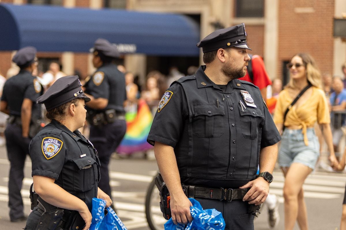 NYPD officers maintain order while engaging with celebrants at New York Pride Parade.