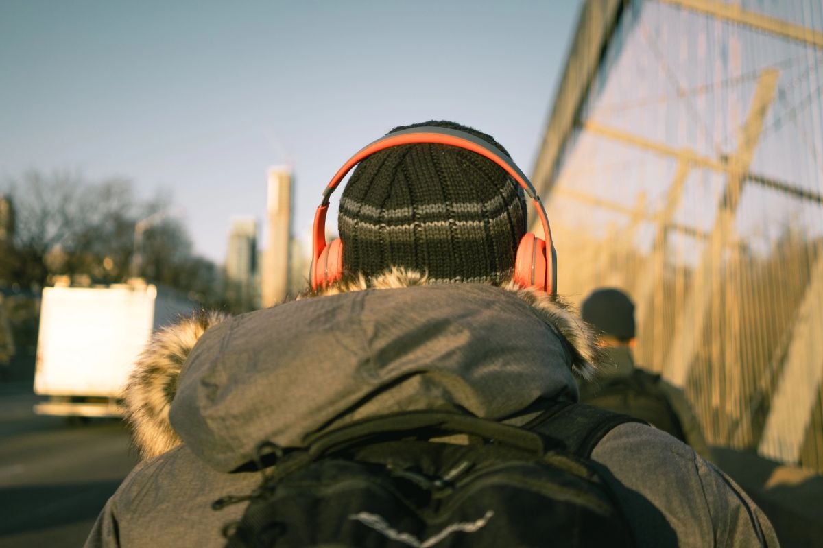 Man walks to work wearing parka and beanie.