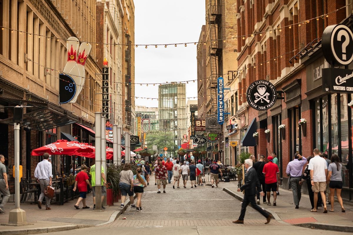 People walk by bars and restaurants along busy 4th street in the downtown core of Cleveland Ohio.