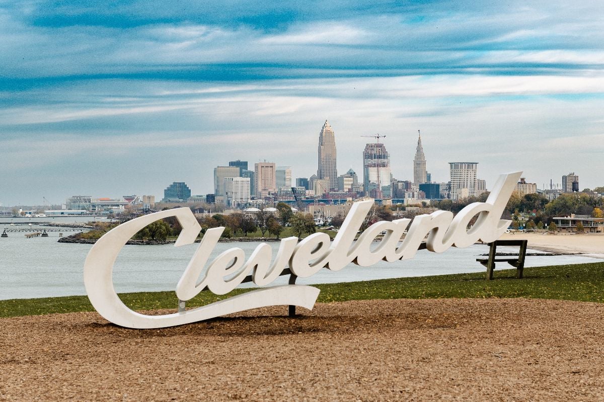 Cleveland Script sign at Edgewater park with city skyline in the background.
