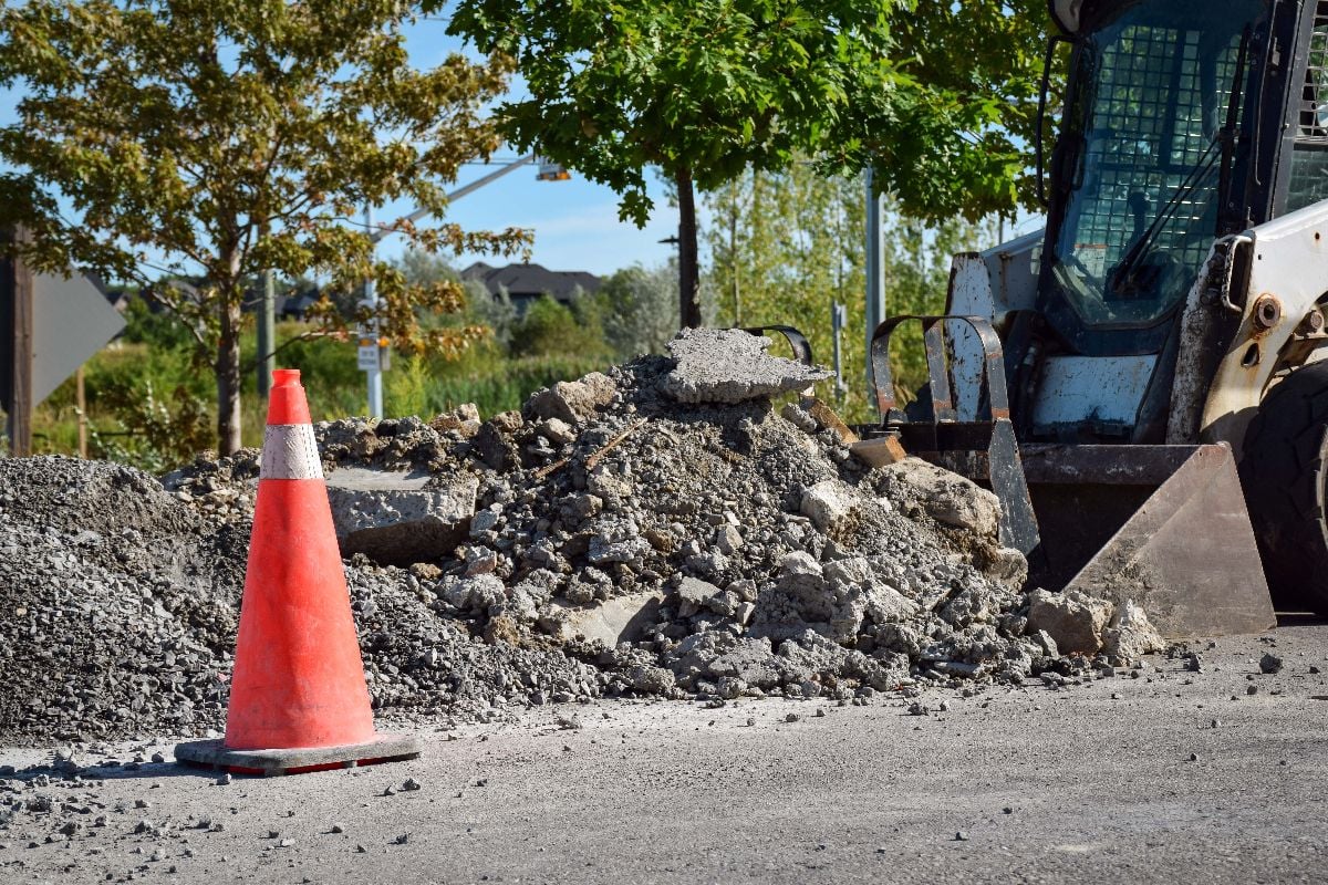 Pile of broken asphalt and concrete rubble at a road work site.