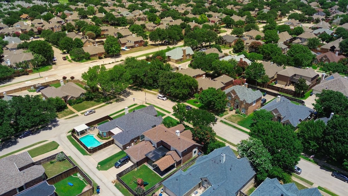 Landscaped boulevard in North Texas lined with two-story suburban homes.