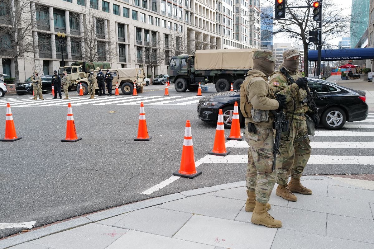 Two national guardsmen stand guard across the street from a checkpoint along Pennsylvania Avenue.
