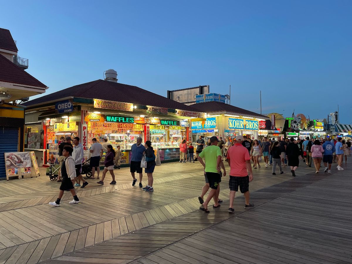 Diners illuminated by neon lights in the boardwalk.