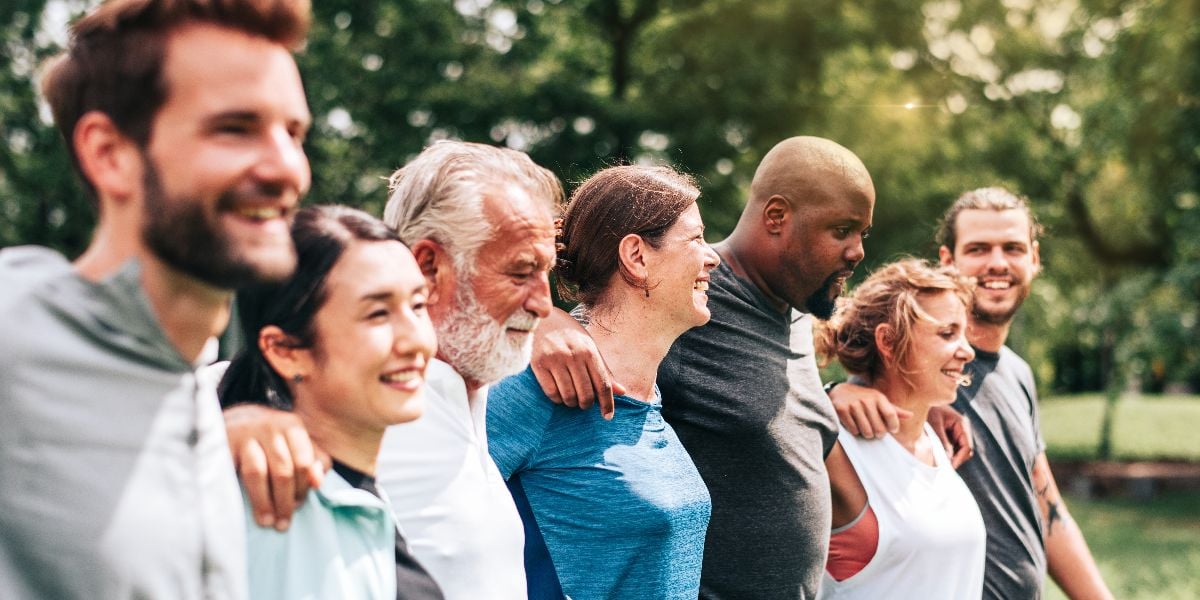 Diverse group of people outdoors, smiling and bonding.
