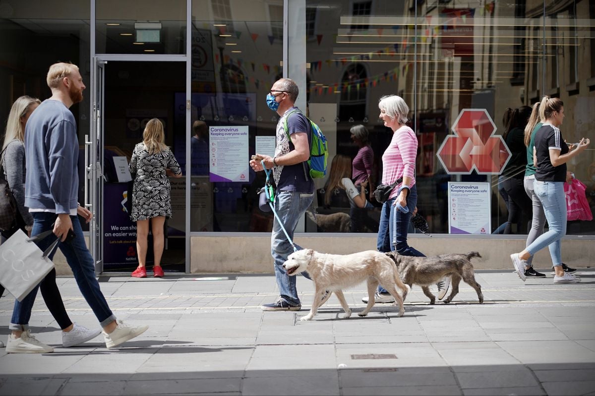 People walk along a busy shopping street.