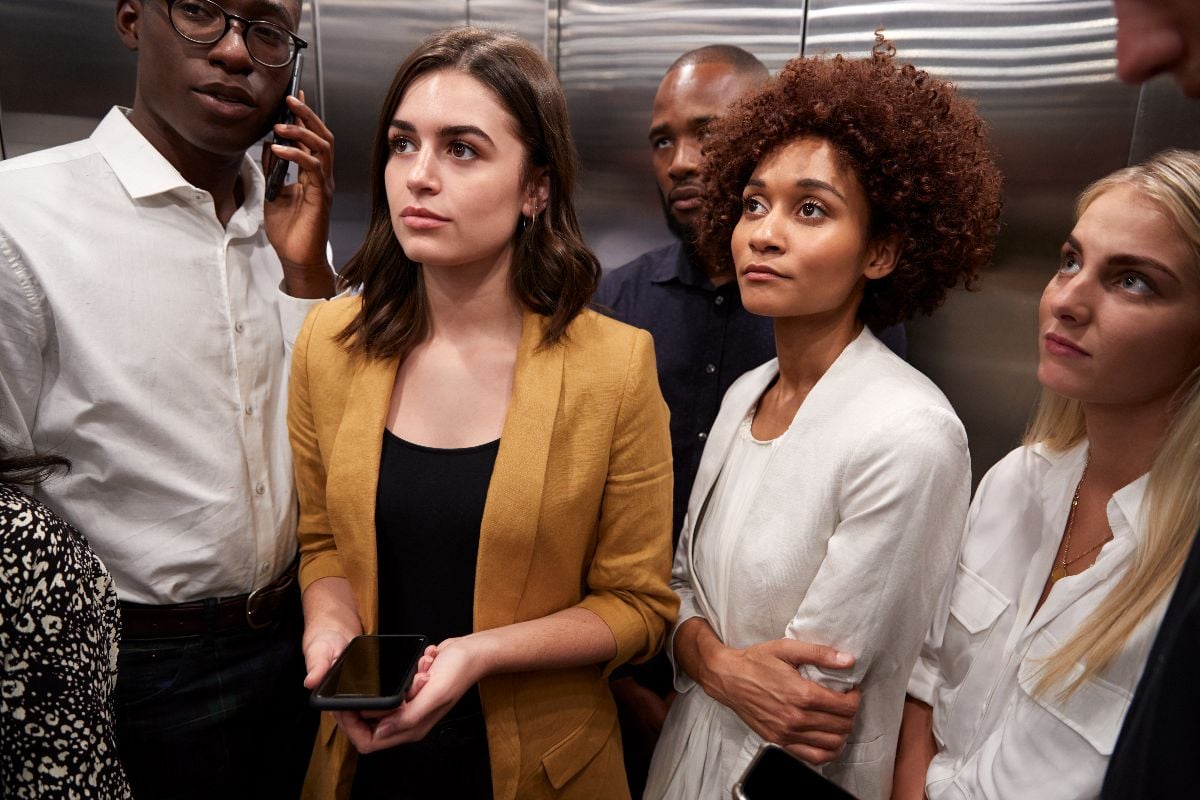 Work colleagues standing in an elevator at their office.