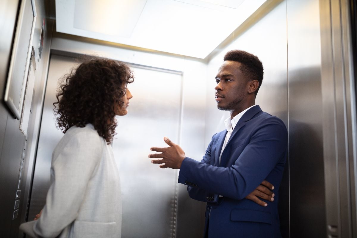 Business people having conversation in elevator.