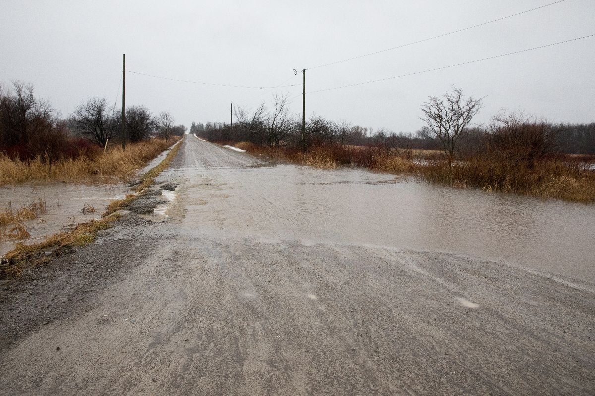 Water flooding over a road after a sudden thaw.