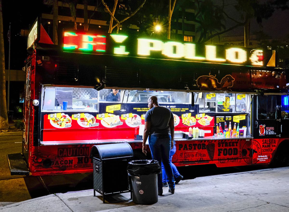 Man at taco food truck at night.