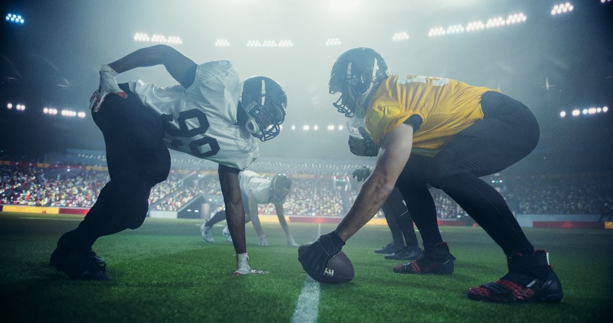 American football match with players face-off before action.