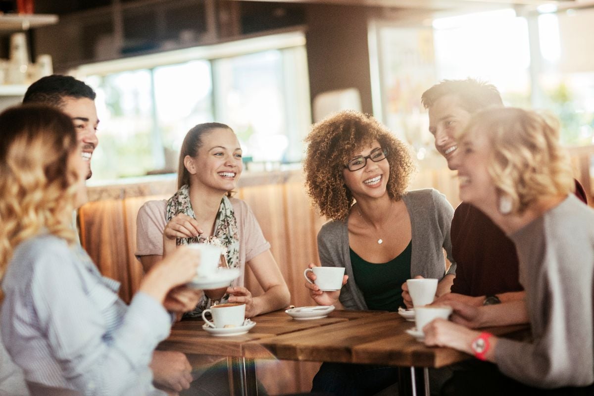 Young and diverse group of people having coffee together at a cafe in the city.