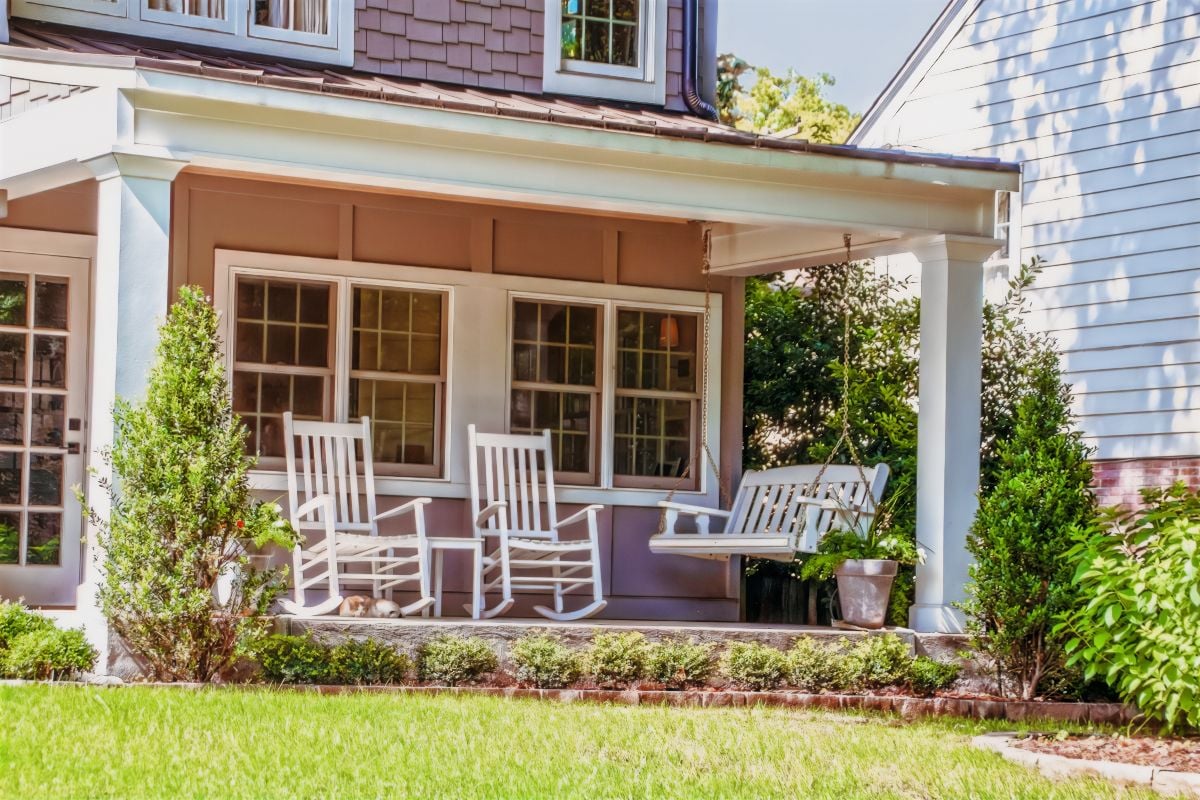 Front porch with two rocking chairs and a porch swing.
