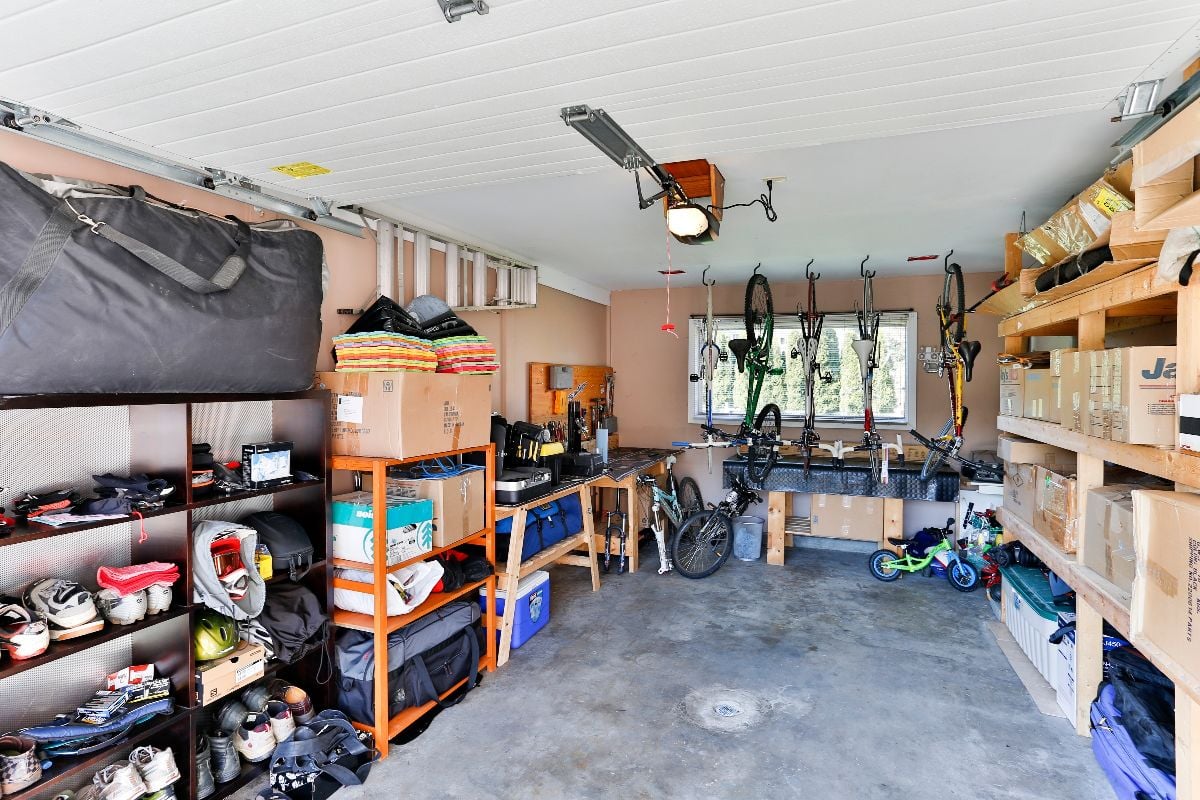 An organized garage storage filled with personal stuff and junk stacked on shelves.