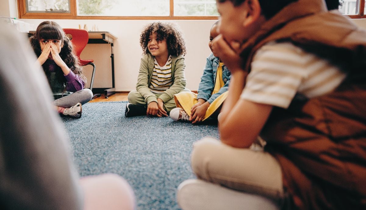 Group of children sitting in a circle in a classroom.