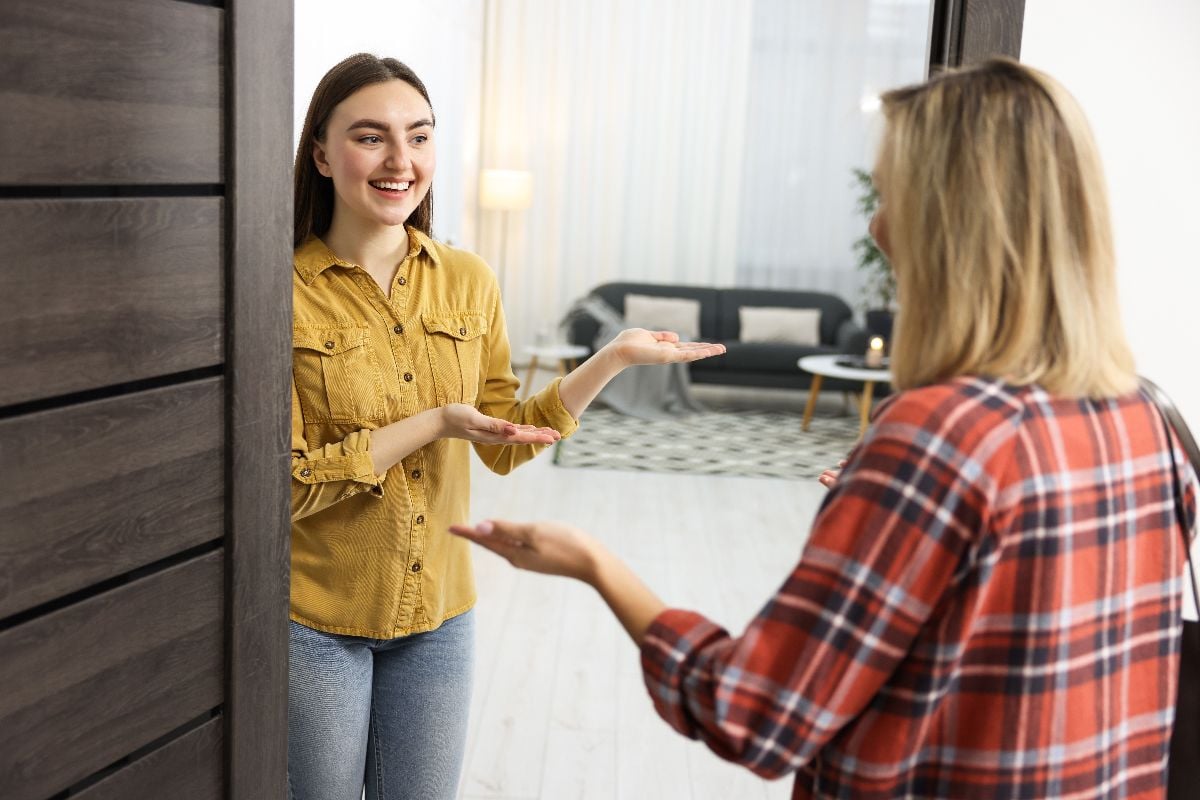 Woman welcoming friend to her apartment.