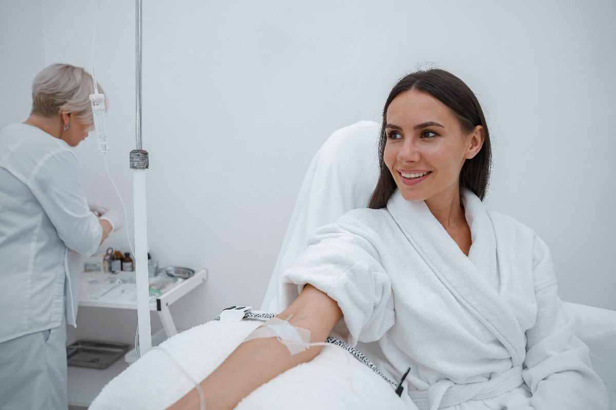 Beautiful woman in white bathrobe during medical procedure in beauty clinic.