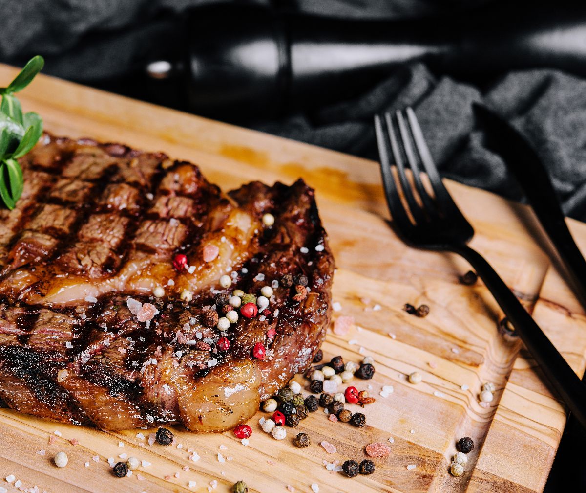 New York beef steak on wooden board.