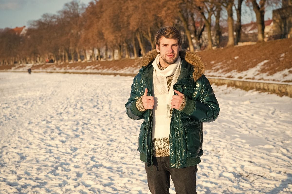 Man in layered clothes on a winter landscape.