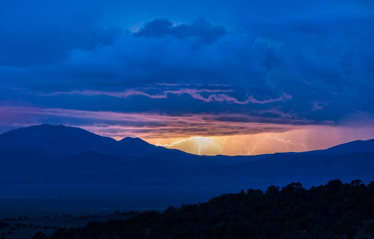 A lightning storm rages in the sky above Shoshone Mountain in the Toquima Range during blue hour.