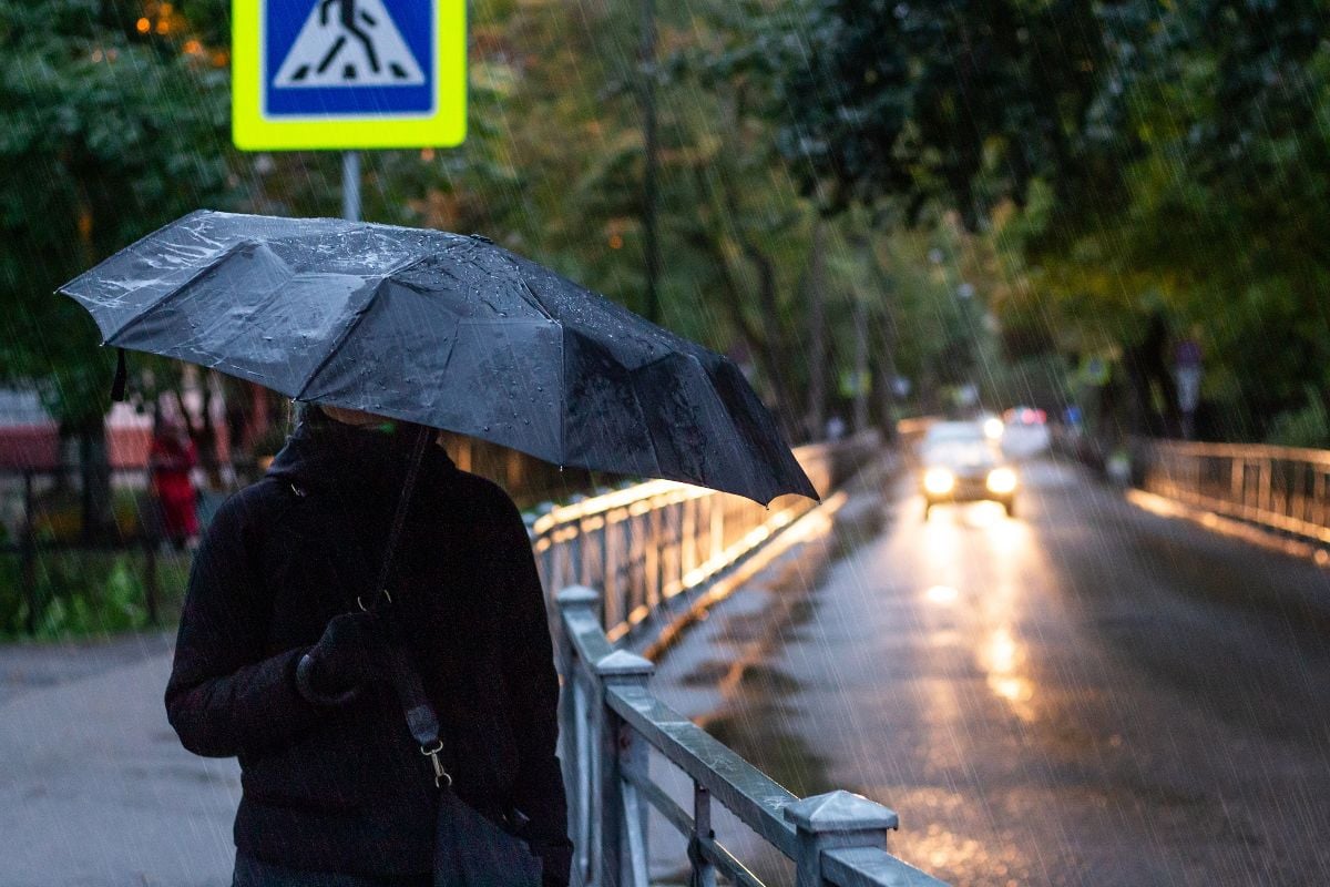 Man holding umbrella outside during the rain.