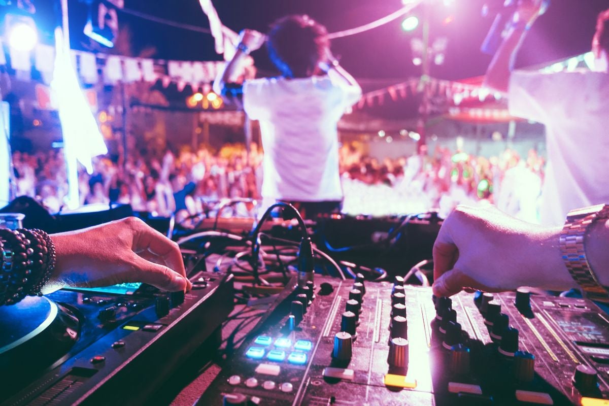 Dj mixing outdoor at beach party festival outdoor.