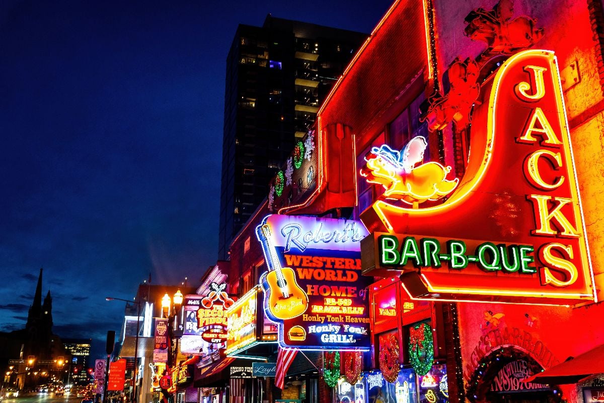 Neon signs of blues clubs on Beale street illuminated at night in downtown Nashville city attraction.