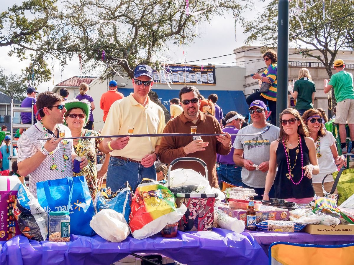 Mardi Gras Parade Spectators on the St. Charles Avenue parade route prepare to take shots from a shotski.