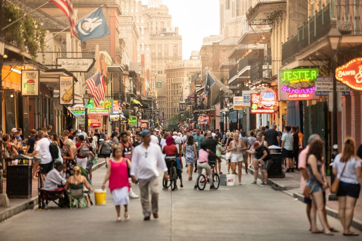 Crowds of people party and walk along the French Quarter bars and restaurants.
