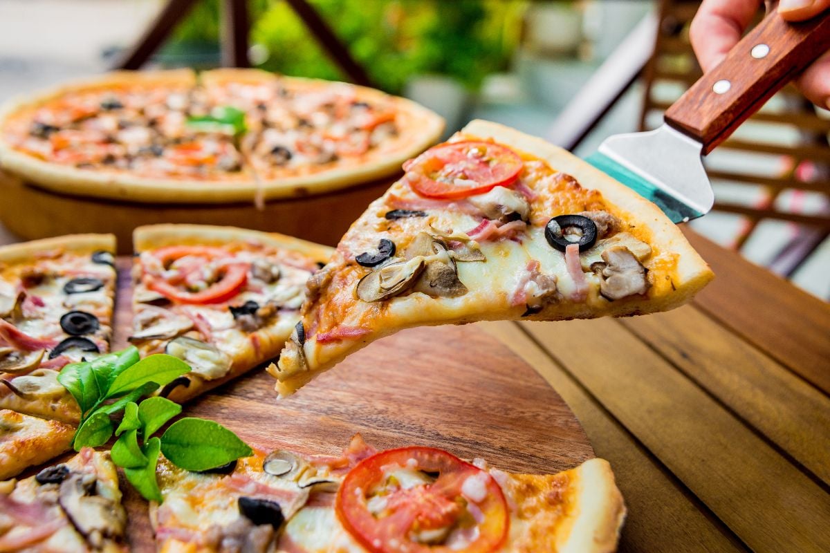 Large pizza on a wooden table.