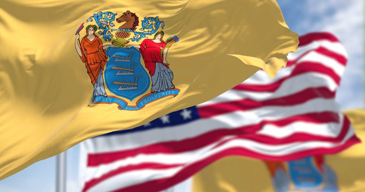 The New Jersey state flag waving along with the national flag of the United States of America.