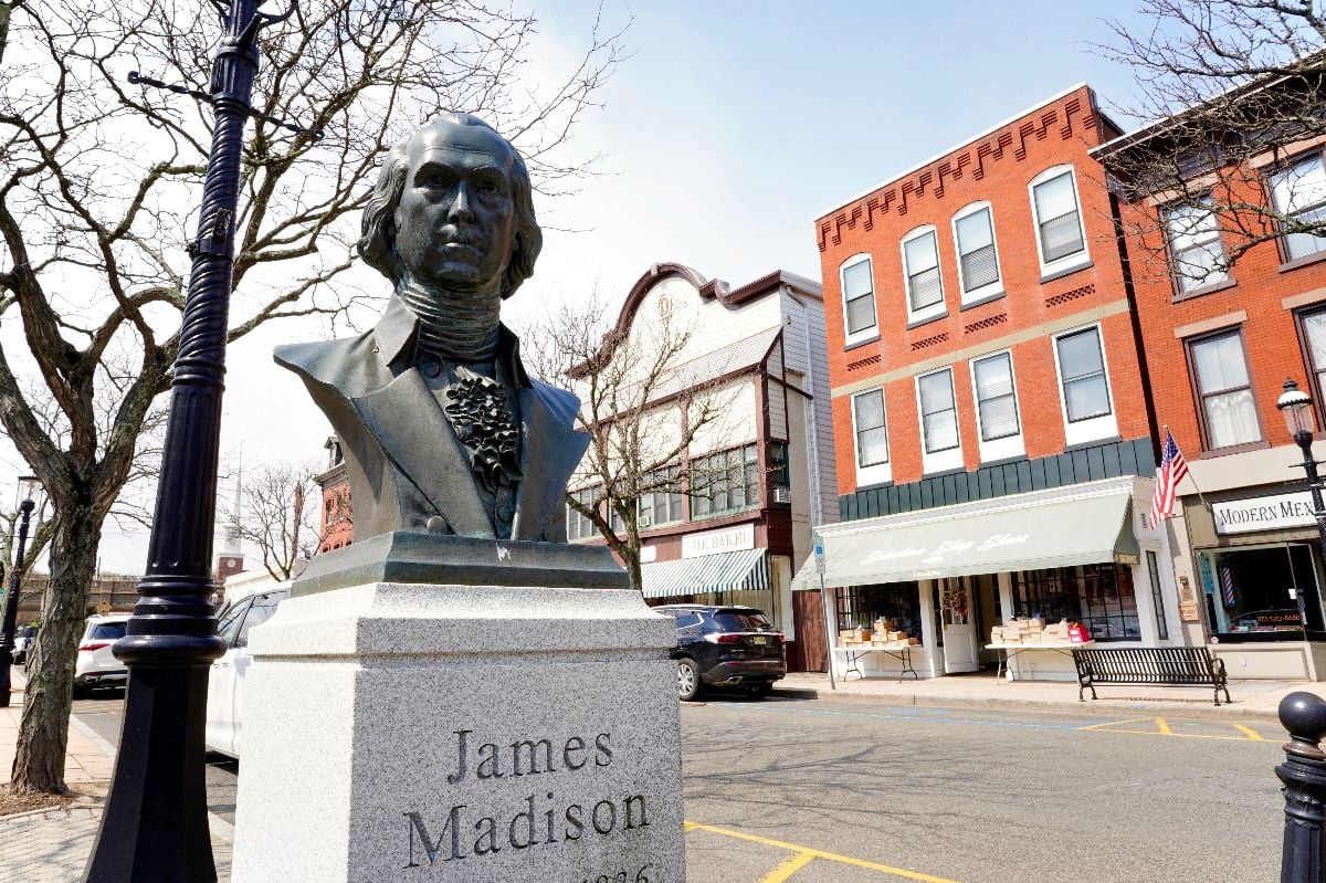 Main Street with a landmark clock, colorful shops, restaurants, and patriotic monuments.