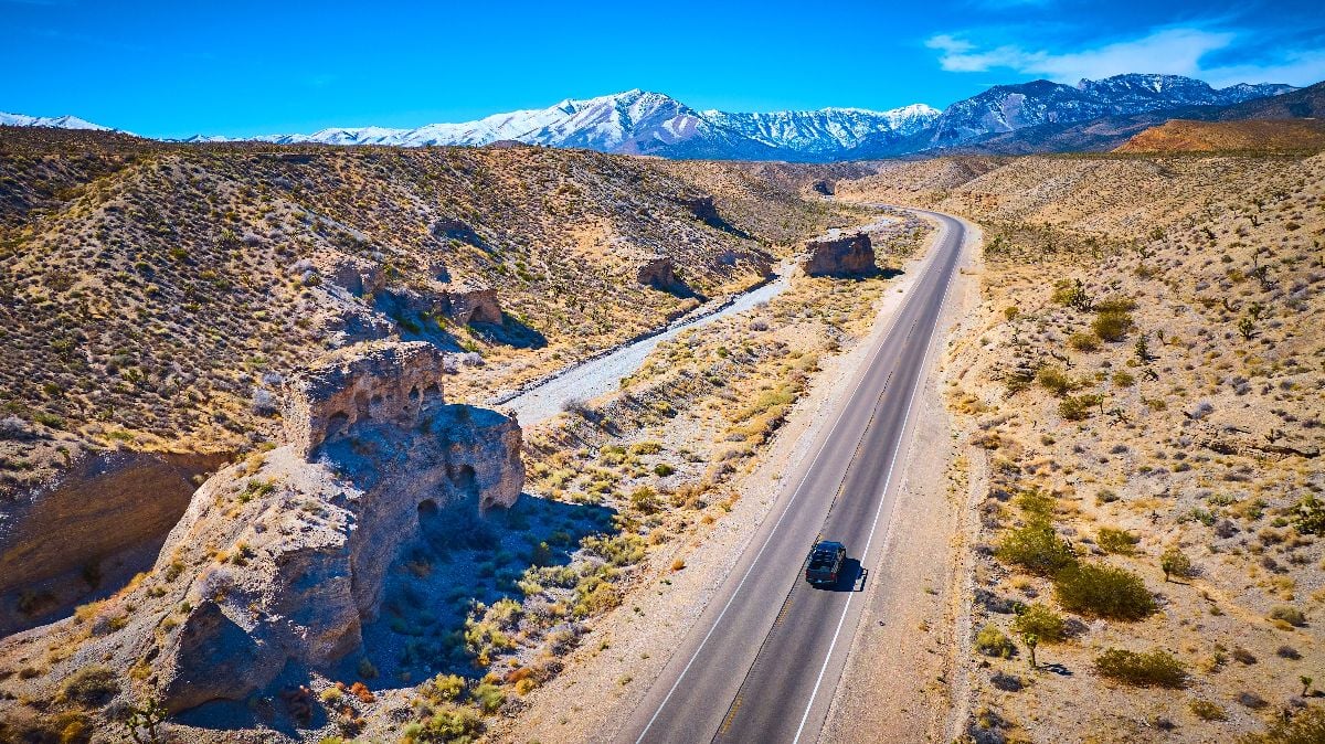 Aerial of desert road and snow-capped mountains in Nevada