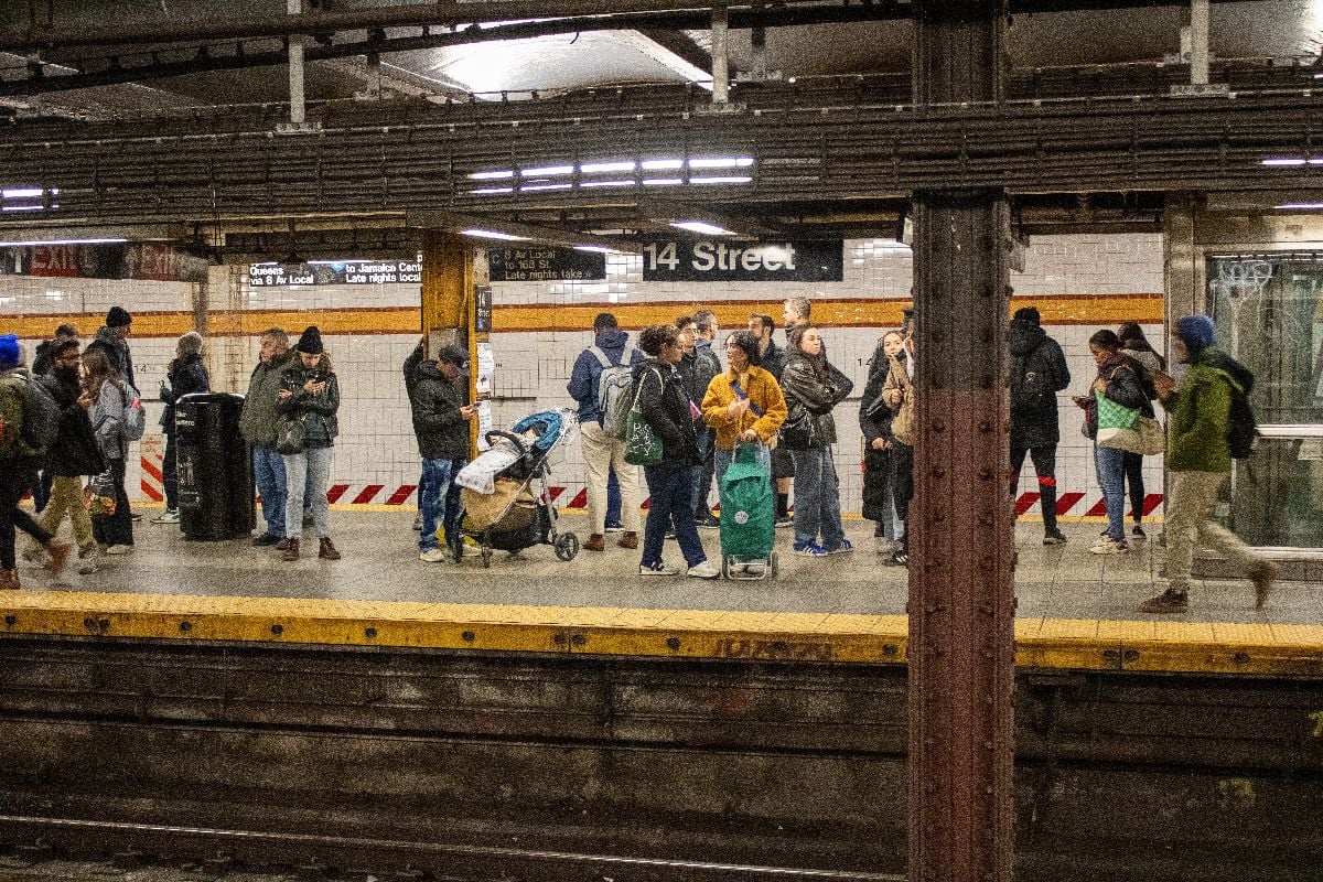 Pedestrians in subway station waiting for train.
