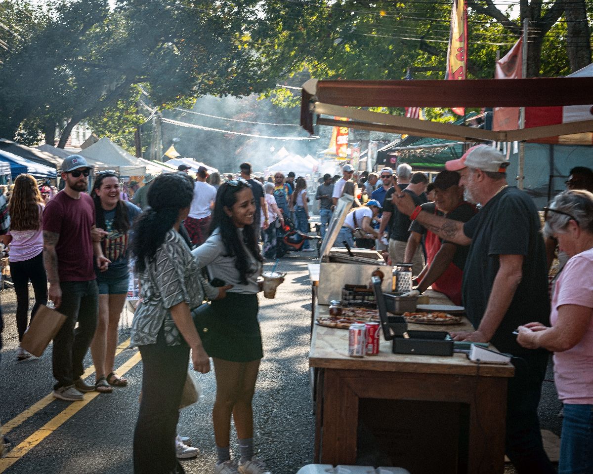 People enjoy the food stalls at the Fall Festival street fair.
