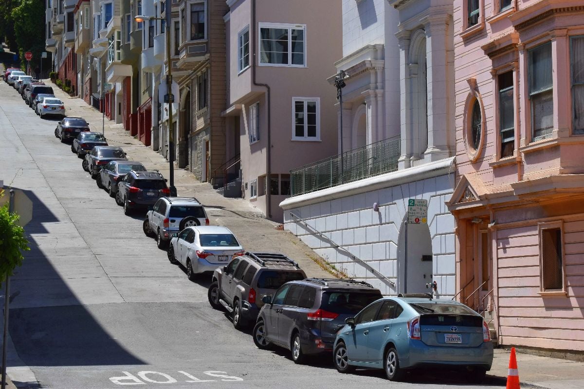 Cars parked on a steep road.
