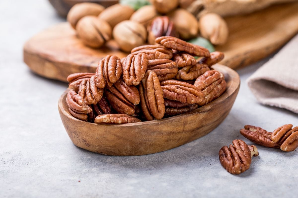 Pecan nuts on a wooden bowl.