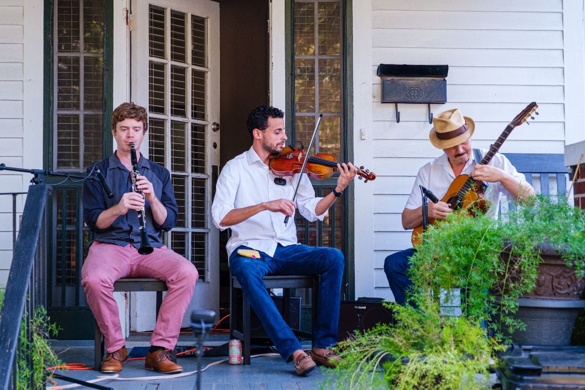 Gypsy jazz musicians at front porch concert in uptown neighborhood.
