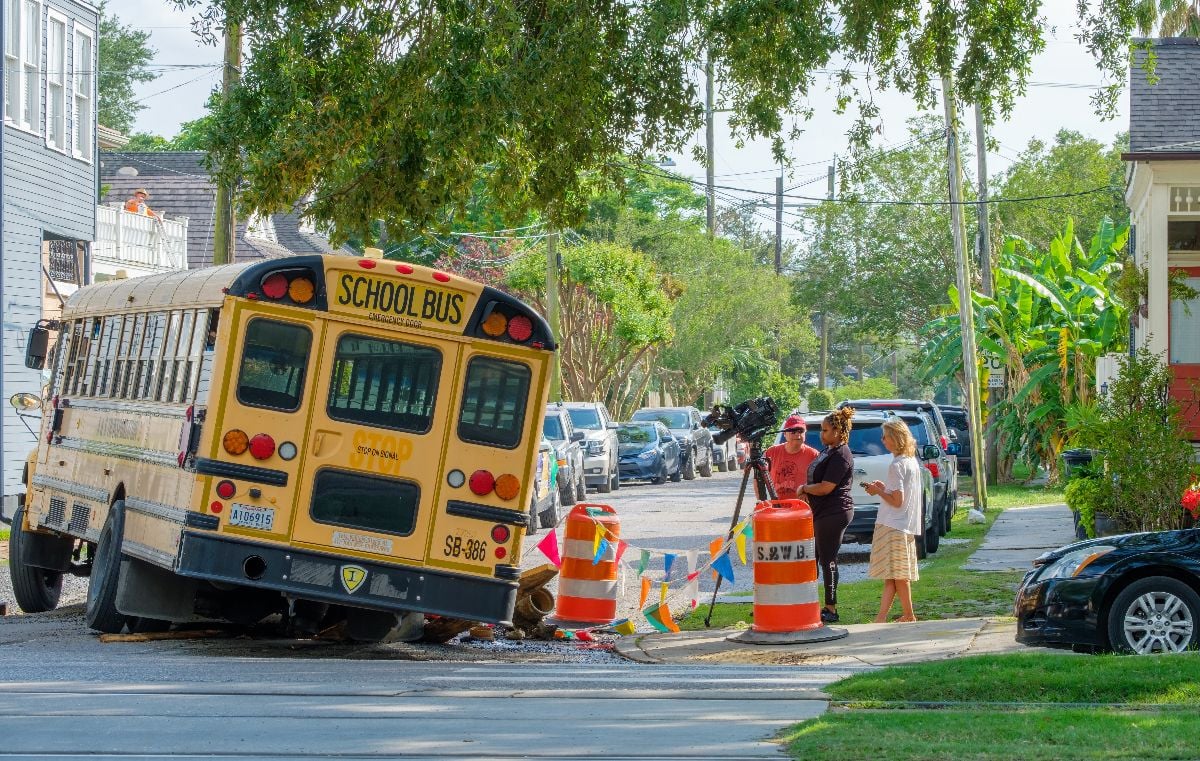 Television news crew at the site of a public school bus wrecked by a pothole in Uptown New Orleans neighborhood.