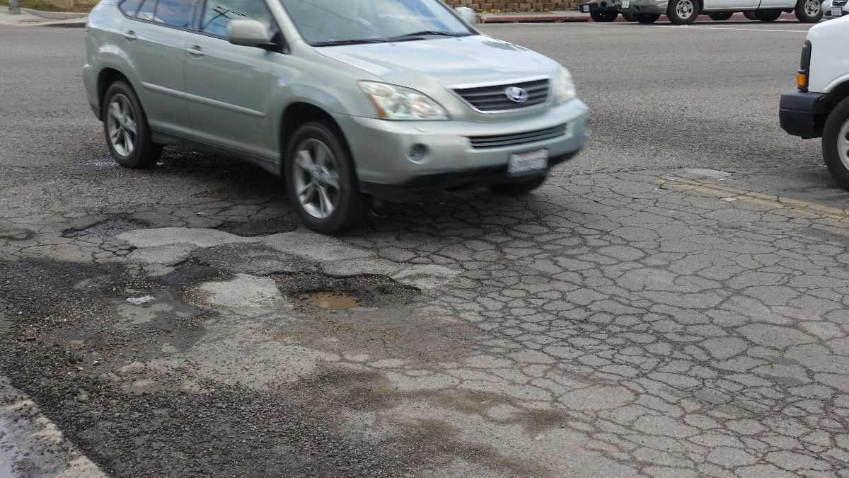 A car swerves to avoid nasty potholes.