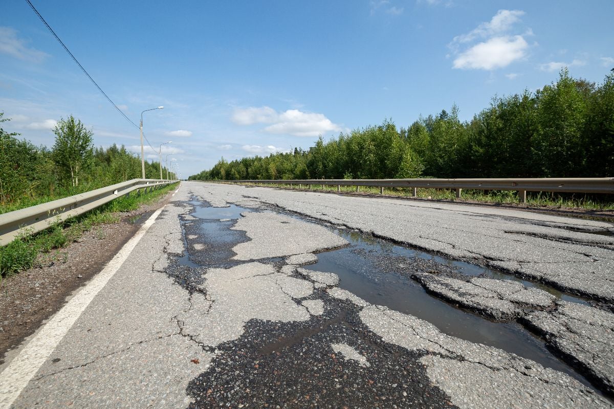 Potholes on bad asphalt road.