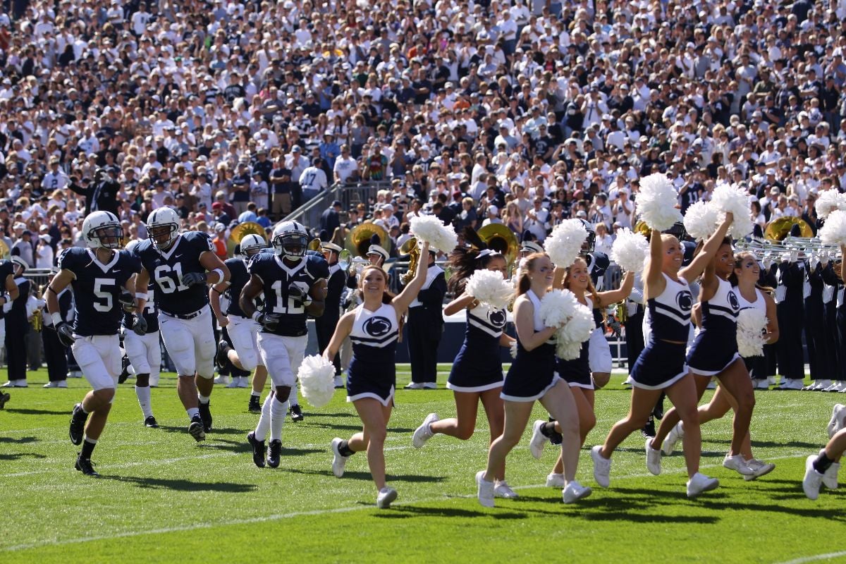 Penn State state players and cheerleaders enter the field before the game.