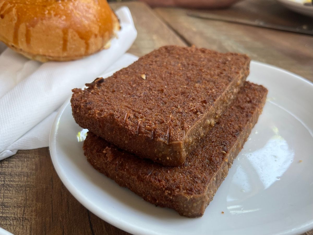 A side order of scrapple on a wooden table.