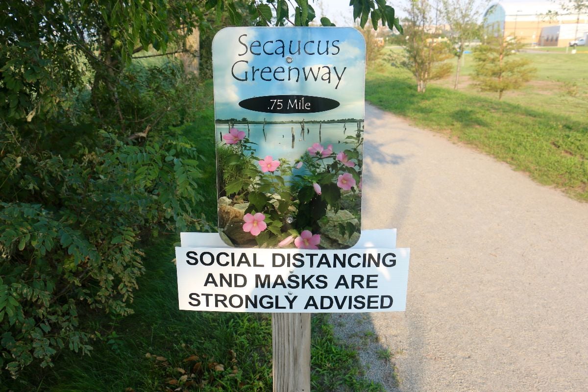 Social distancing and masks PSA sign at the Secaucus Greenway.