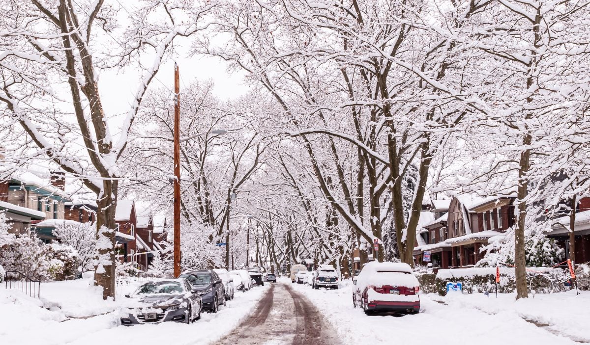 Cars parked along snowy streets in the Regent Square neighborhood of the city on a winter day.