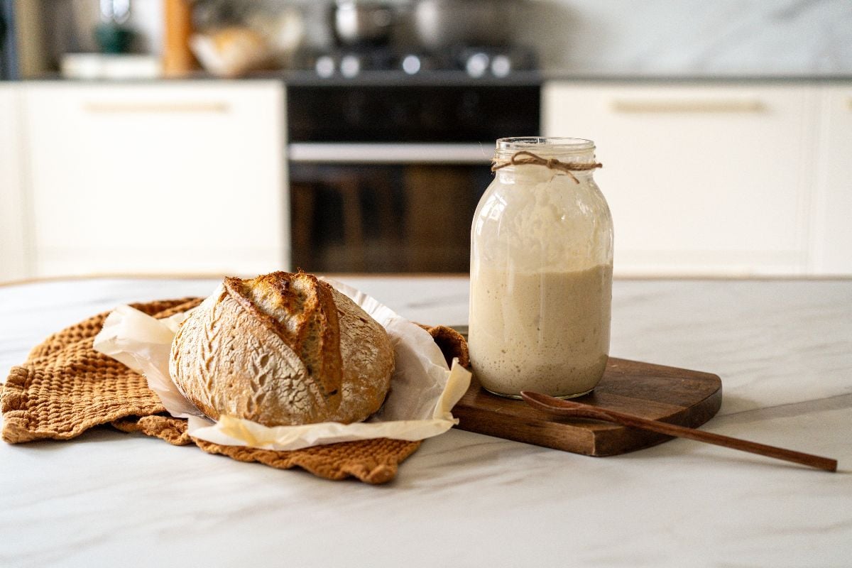 Crispy sourdough bread sits beside a glass jar.