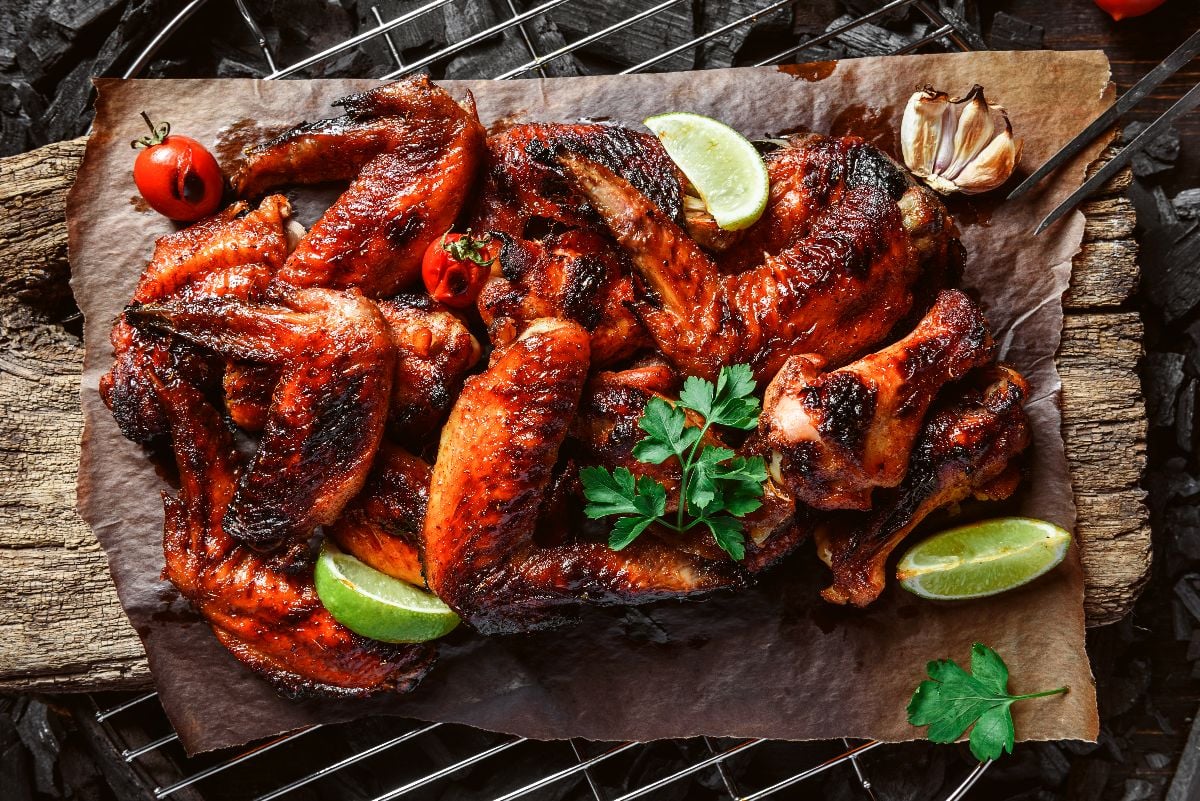 Spicy chicken wings on a rustic board.